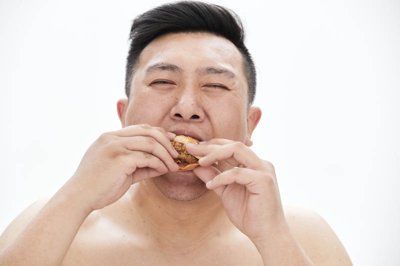 大吃特吃各种食物的肥胖亚洲男子图片