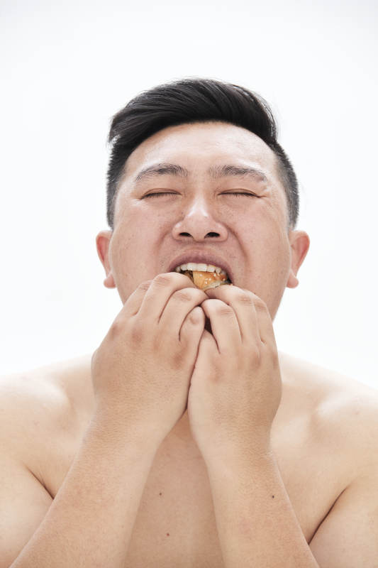 大吃特吃各种食物的肥胖亚洲男子图片