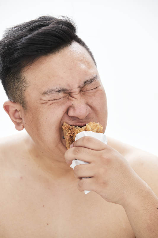 大吃特吃各种食物的肥胖亚洲男子图片