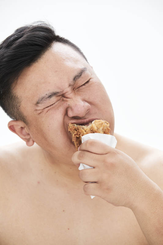 大吃特吃各种食物的肥胖亚洲男子图片