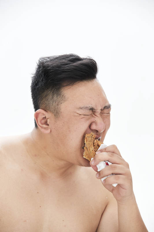 大吃特吃各种食物的肥胖亚洲男子图片