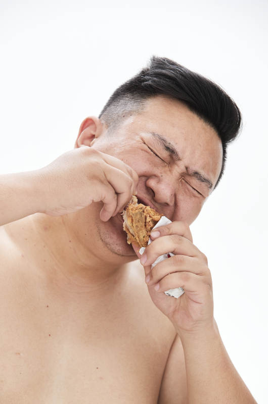 大吃特吃各种食物的肥胖亚洲男子图片