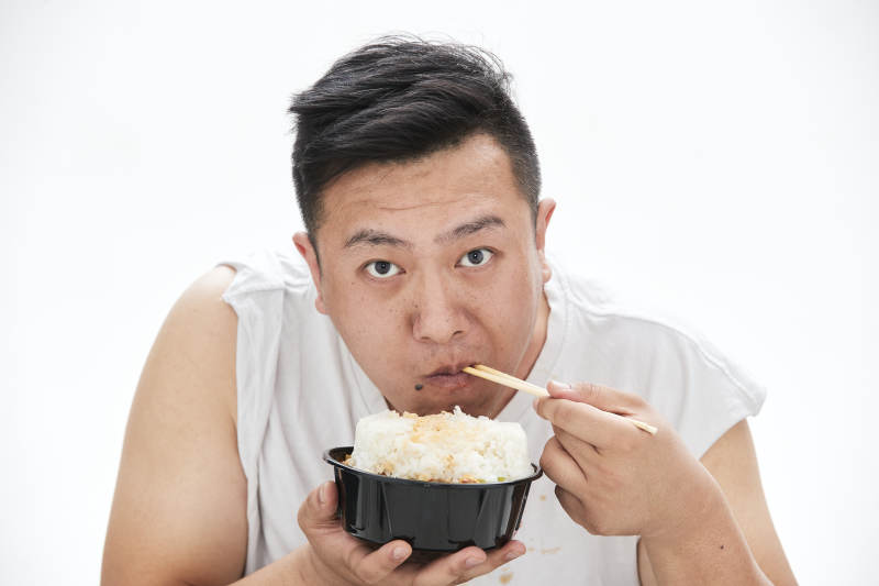大吃特吃各种食物的肥胖亚洲男子图片