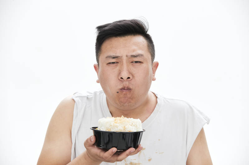 大吃特吃各种食物的肥胖亚洲男子图片