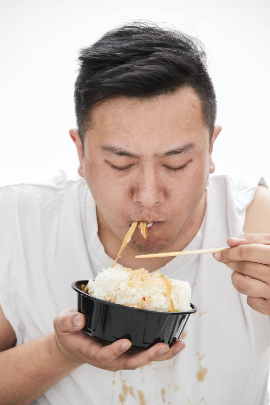 大吃特吃各种食物的肥胖亚洲男子图片