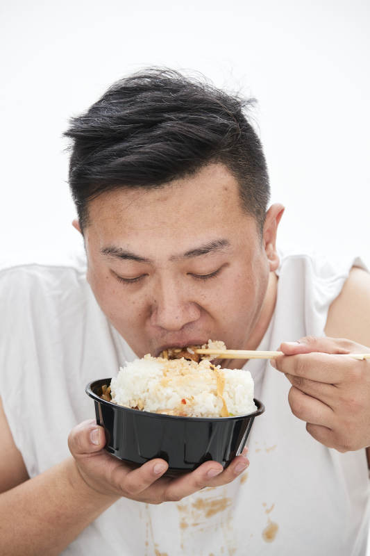 大吃特吃各种食物的肥胖亚洲男子图片