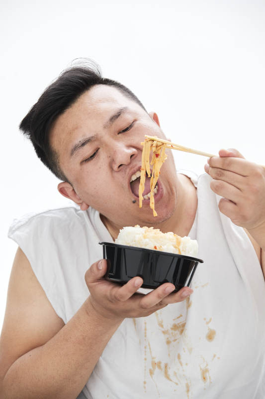 大吃特吃各种食物的肥胖亚洲男子图片