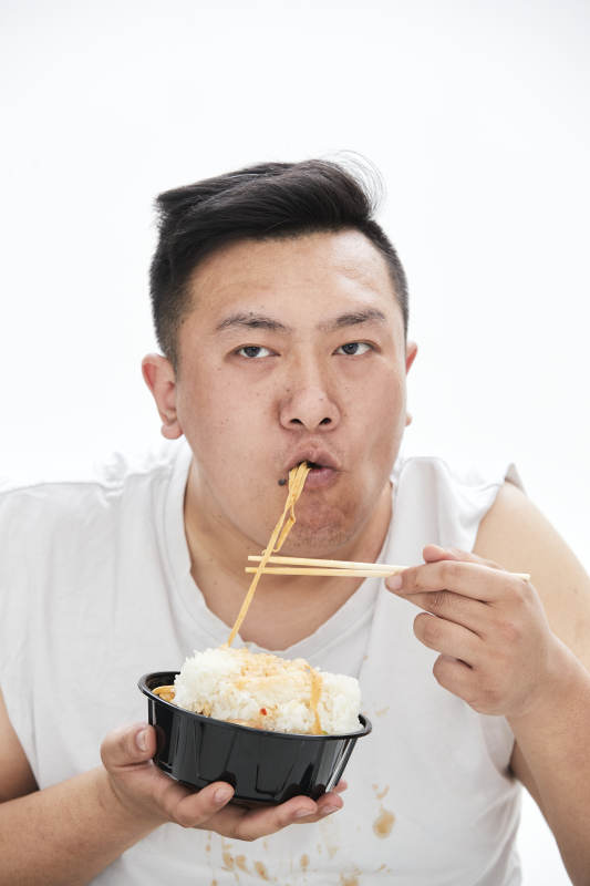 大吃特吃各种食物的肥胖亚洲男子图片