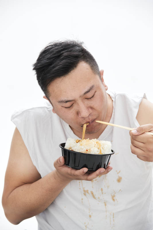 大吃特吃各种食物的肥胖亚洲男子图片