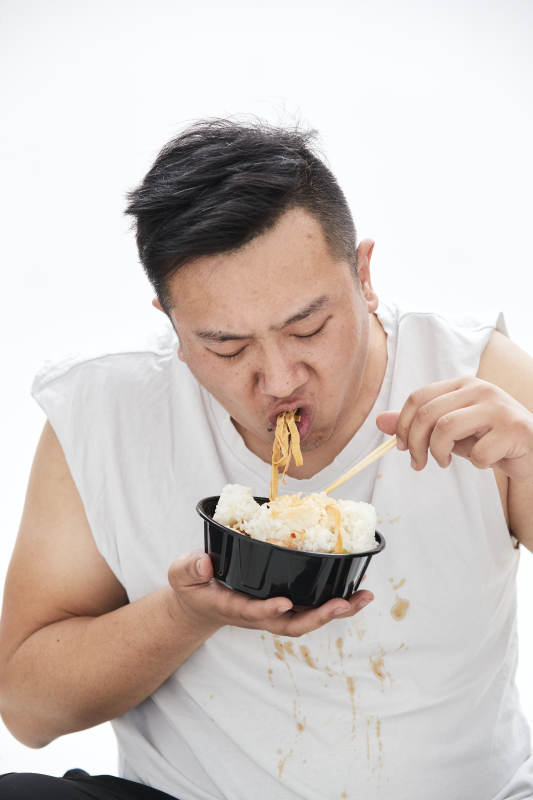 大吃特吃各种食物的肥胖亚洲男子图片