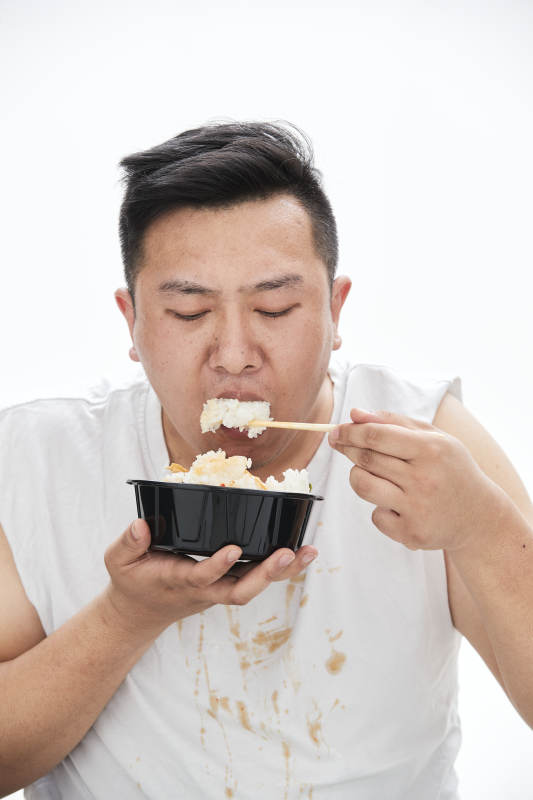 大吃特吃各种食物的肥胖亚洲男子图片