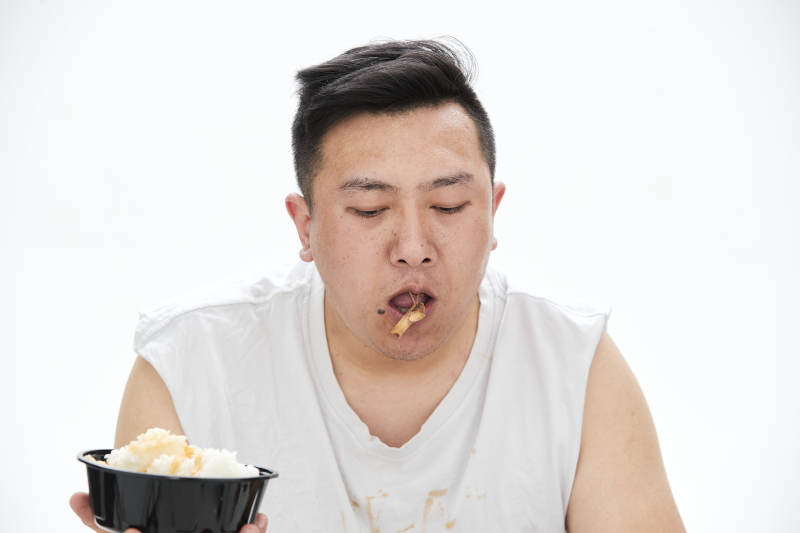 大吃特吃各种食物的肥胖亚洲男子图片