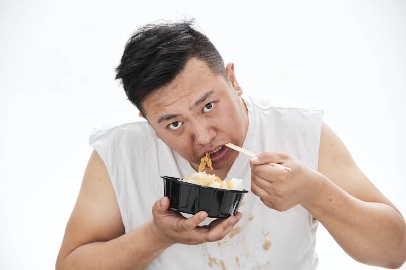大吃特吃各种食物的肥胖亚洲男子图片