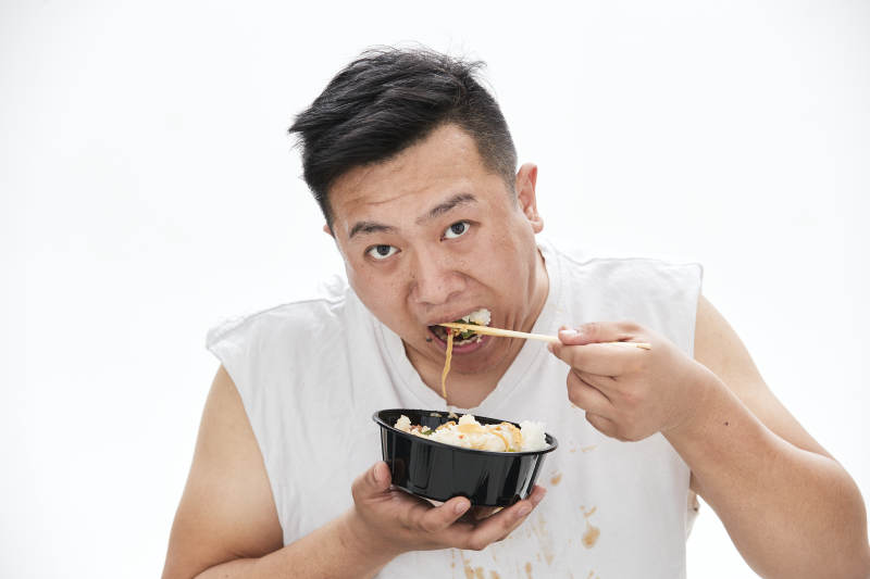 大吃特吃各种食物的肥胖亚洲男子图片