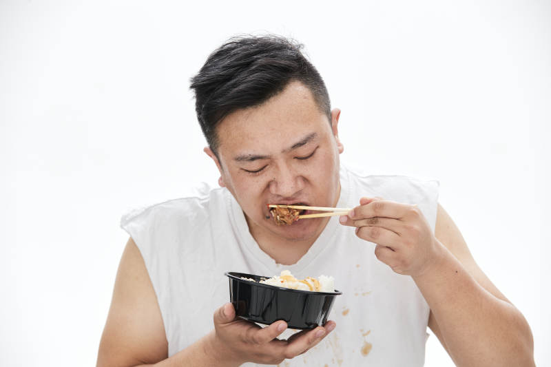大吃特吃各种食物的肥胖亚洲男子图片