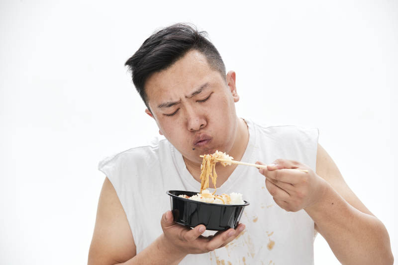 大吃特吃各种食物的肥胖亚洲男子图片