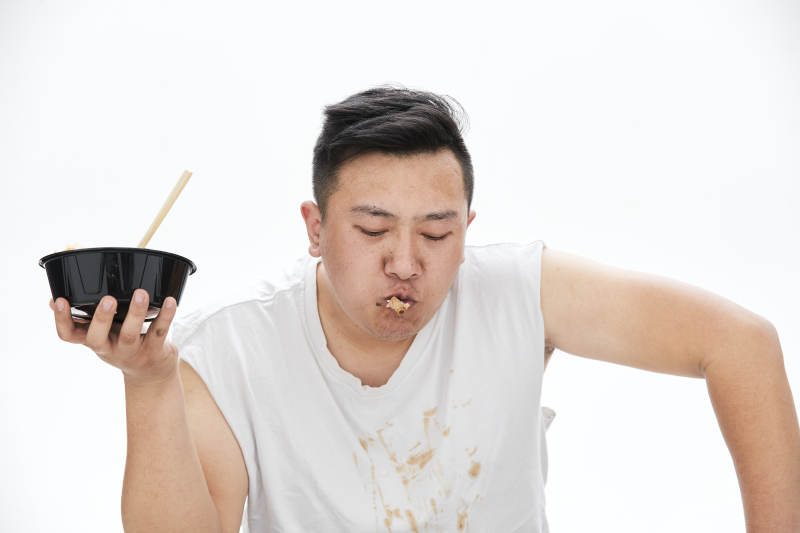 大吃特吃各种食物的肥胖亚洲男子图片