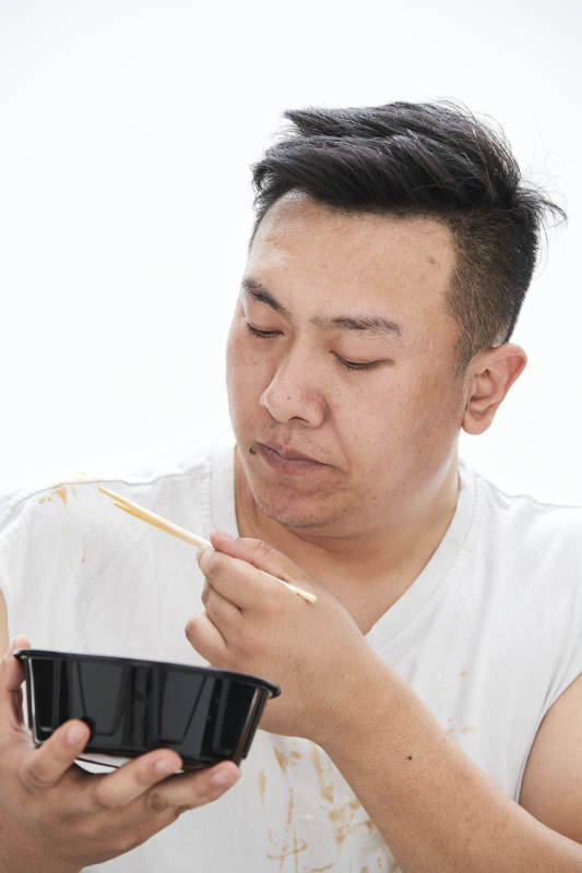 大吃特吃各种食物的肥胖亚洲男子图片