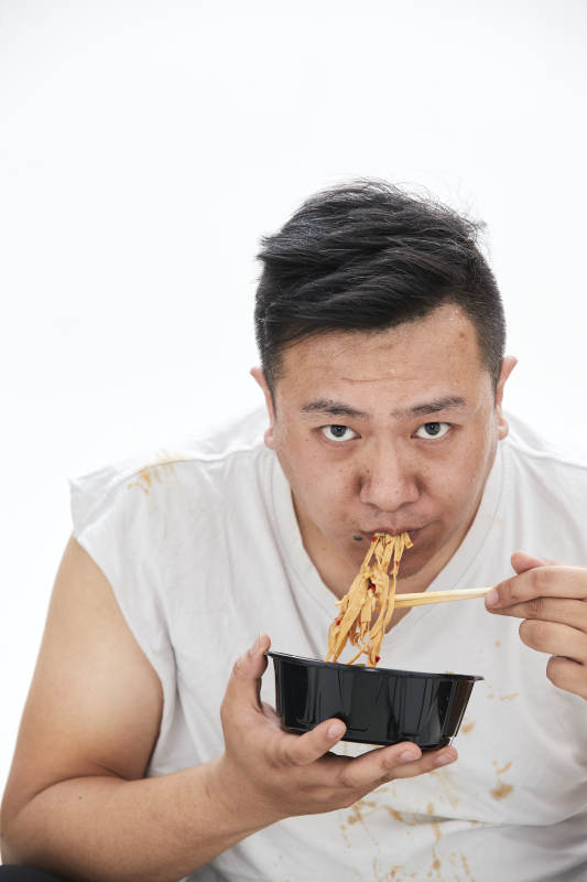 大吃特吃各种食物的肥胖亚洲男子图片