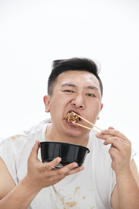 大吃特吃各种食物的肥胖亚洲男子图片