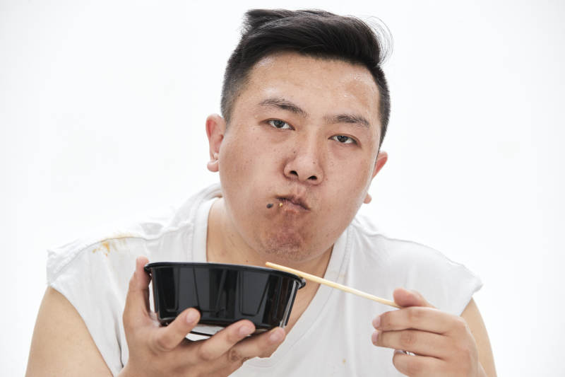 大吃特吃各种食物的肥胖亚洲男子图片