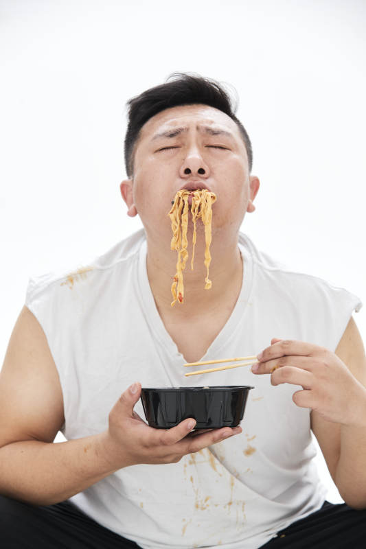 大吃特吃各种食物的肥胖亚洲男子图片