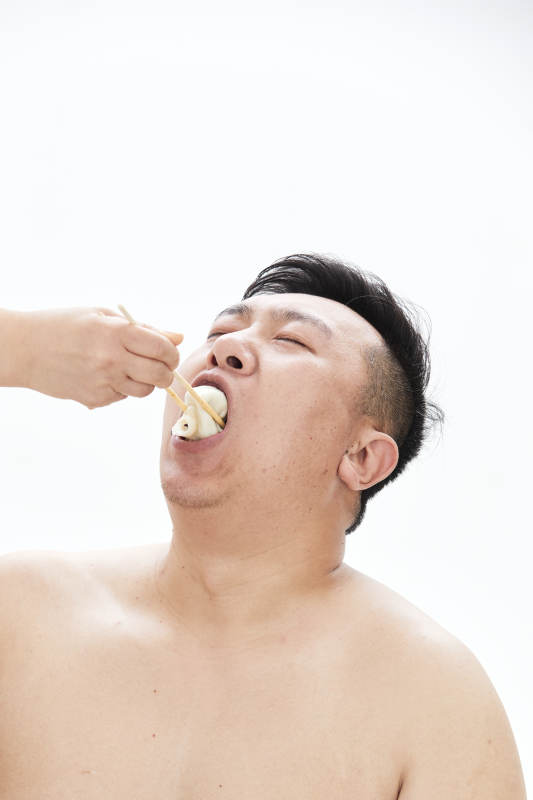 大吃特吃各种食物的肥胖亚洲男子图片