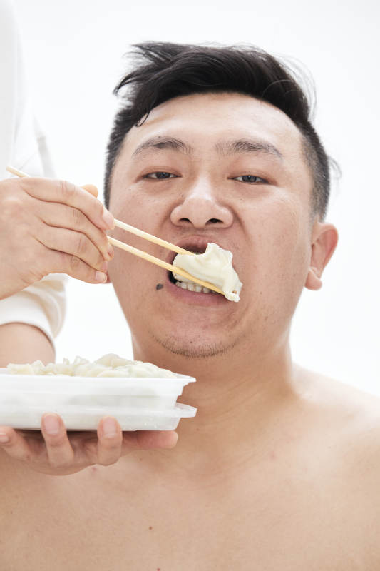 大吃特吃各种食物的肥胖亚洲男子图片