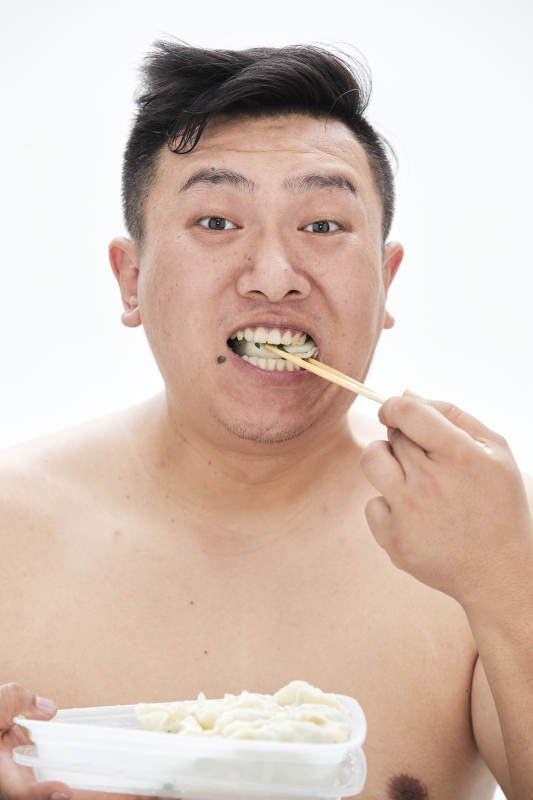 大吃特吃各种食物的肥胖亚洲男子图片