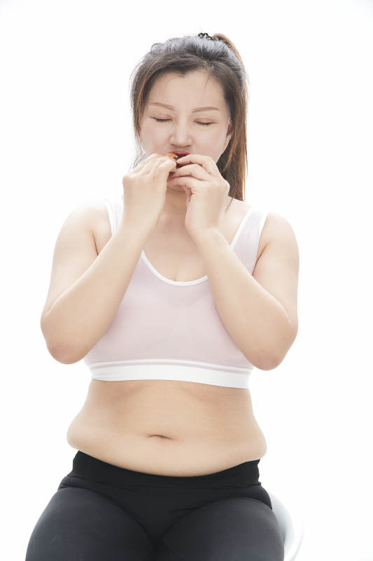因暴饮暴食导致身材走样的亚洲女士图片