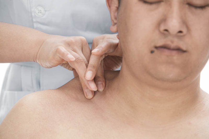 专业按摩师为男子进行肩部按摩图片