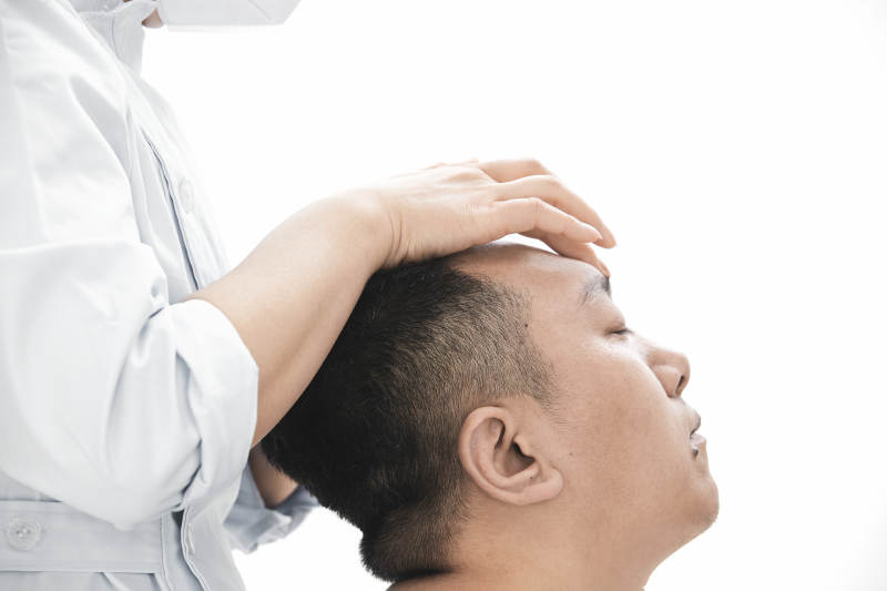 专业按摩师为男子进行头部按摩图片