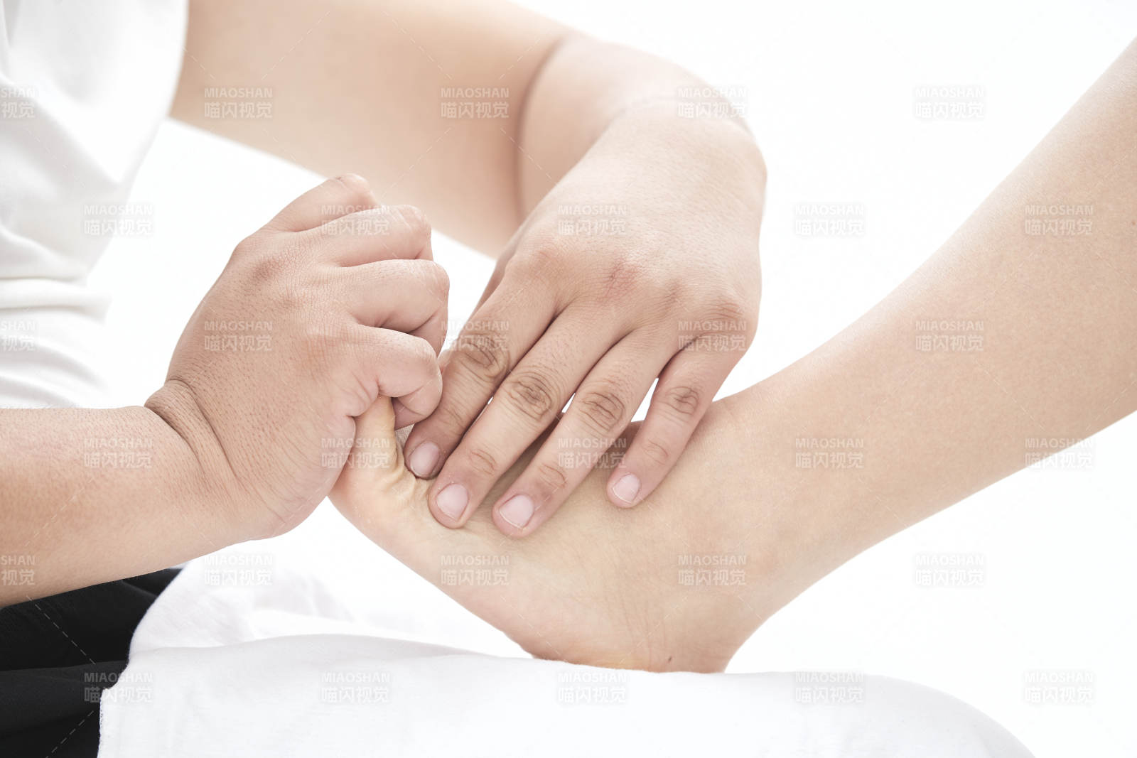 在白色背景上穿着黑色长袜的女人的苗条的腿图片