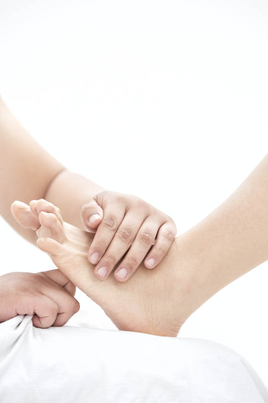 在白色背景上穿着黑色长袜的女人的苗条的腿图片