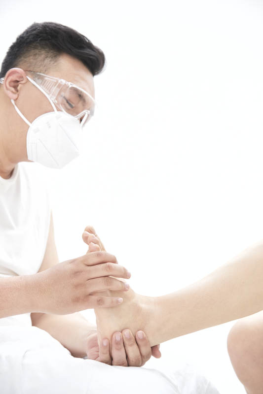 在白色背景上穿着黑色长袜的女人的苗条的腿图片