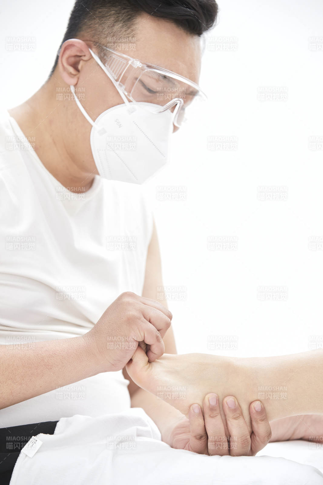 在白色背景上穿着黑色长袜的女人的苗条的腿图片