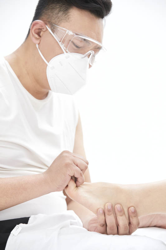 在白色背景上穿着黑色长袜的女人的苗条的腿图片