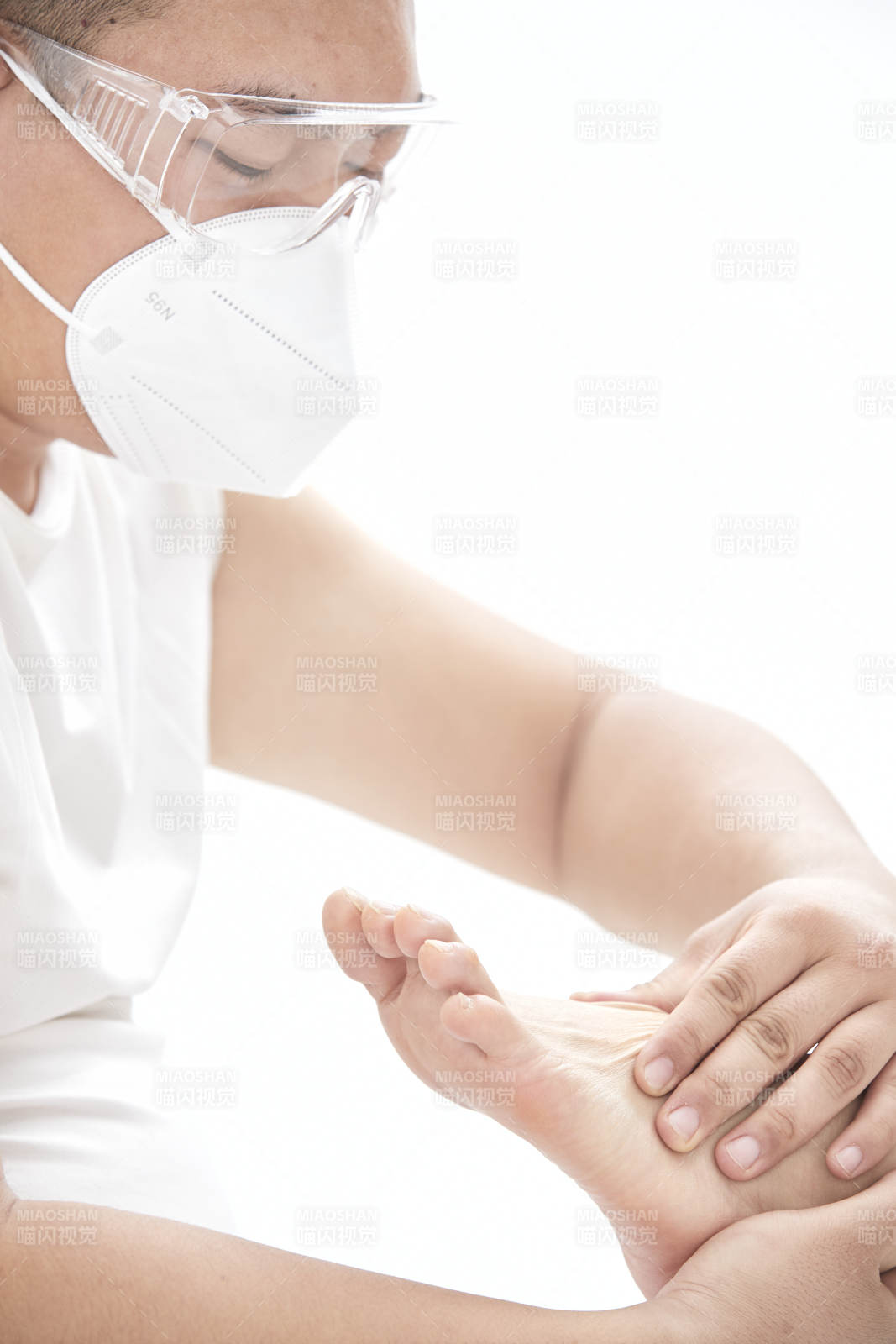 在白色背景上穿着黑色长袜的女人的苗条的腿图片