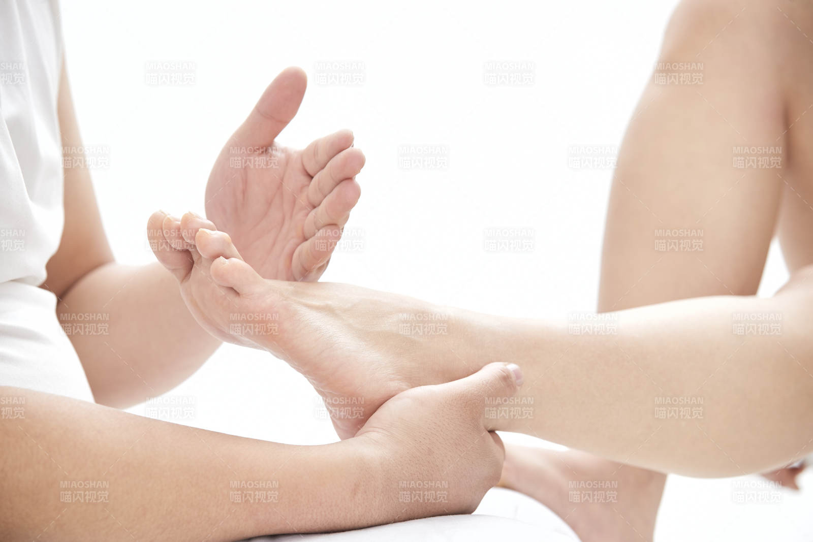 在白色背景上穿着黑色长袜的女人的苗条的腿图片