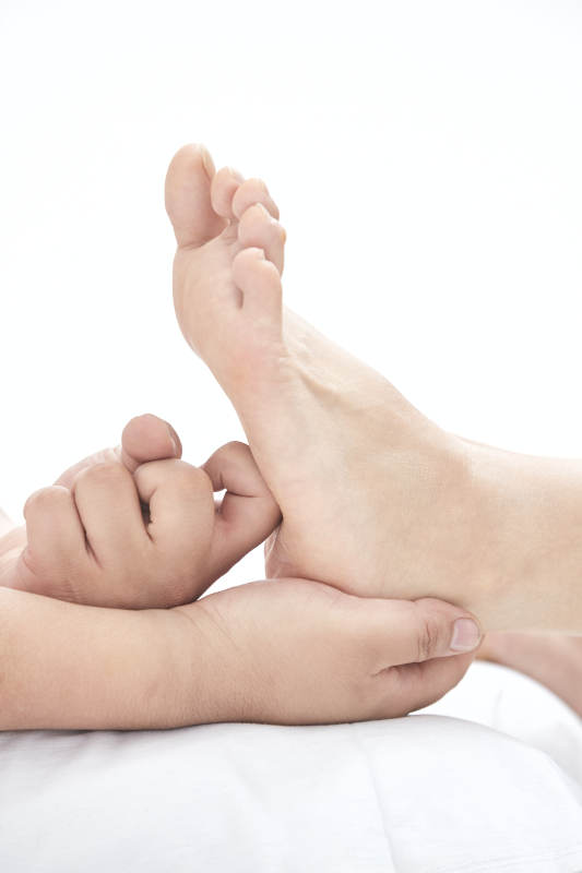 在白色背景上穿着黑色长袜的女人的苗条的腿图片