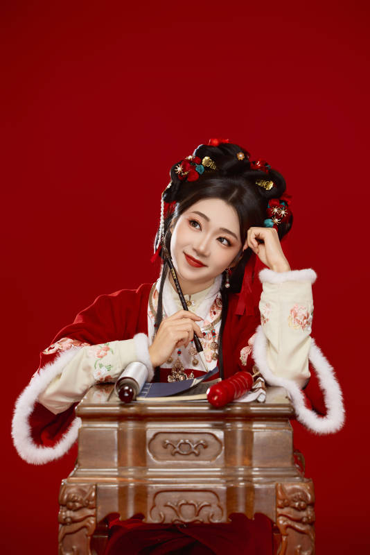 红色背景下身穿喜庆汉服认真学习的中国美女图片
