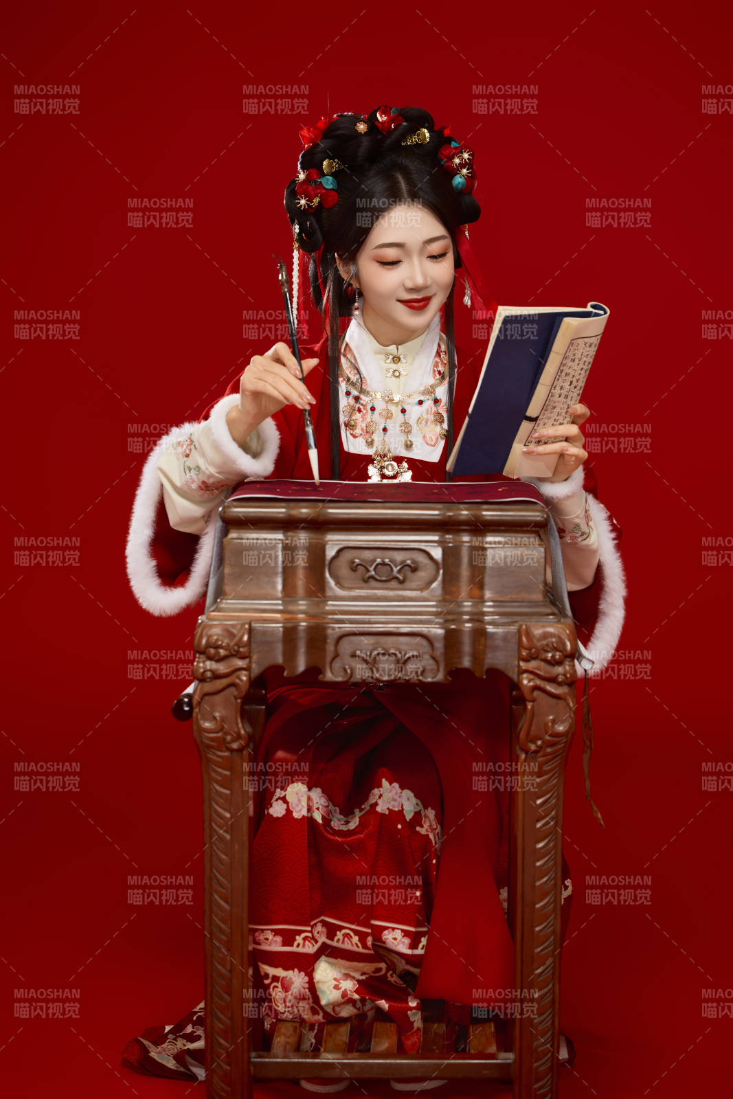红色背景下身穿喜庆汉服认真学习的中国美女图片
