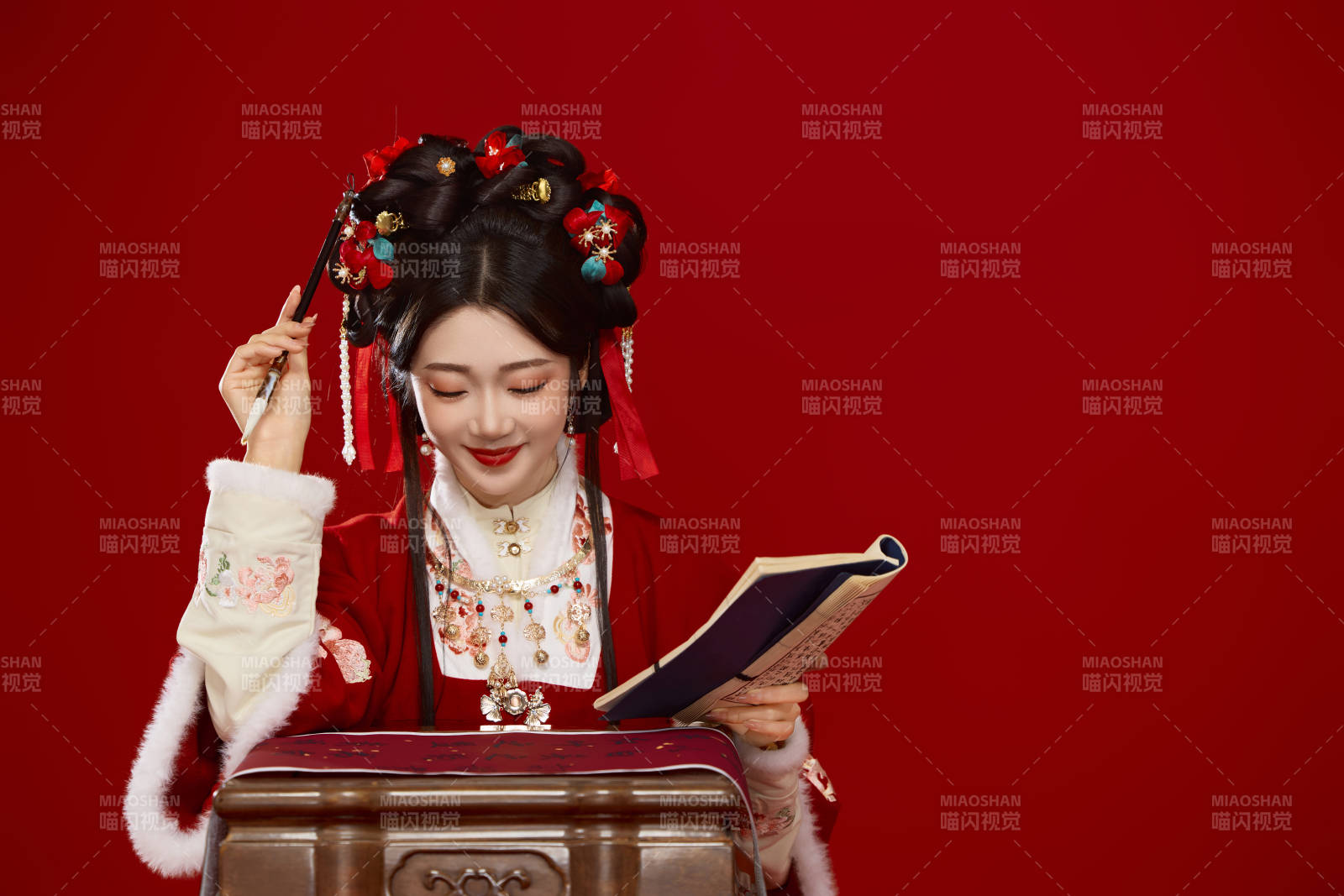 红色背景下身穿喜庆汉服认真学习的中国美女图片