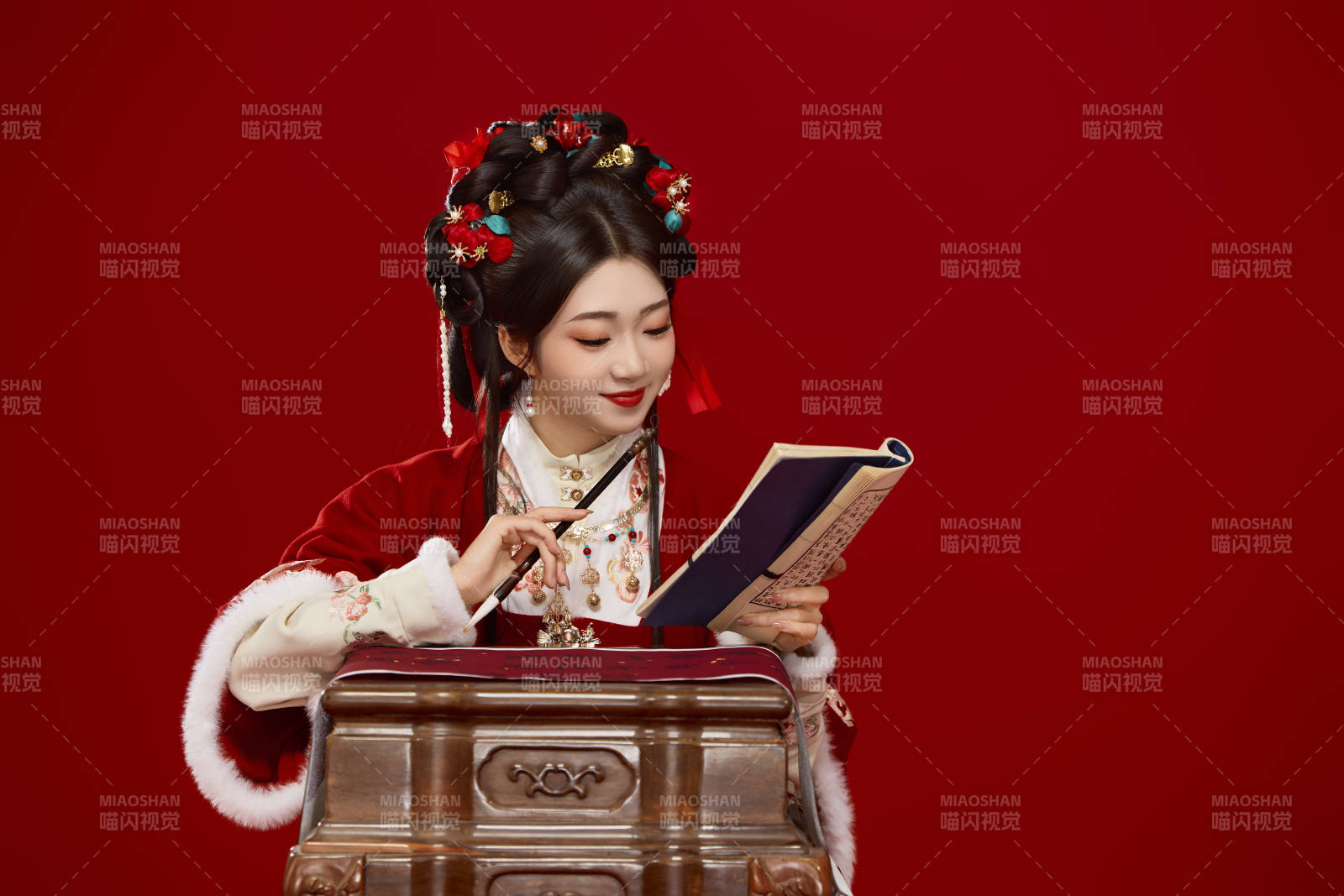 红色背景下身穿喜庆汉服认真学习的中国美女图片