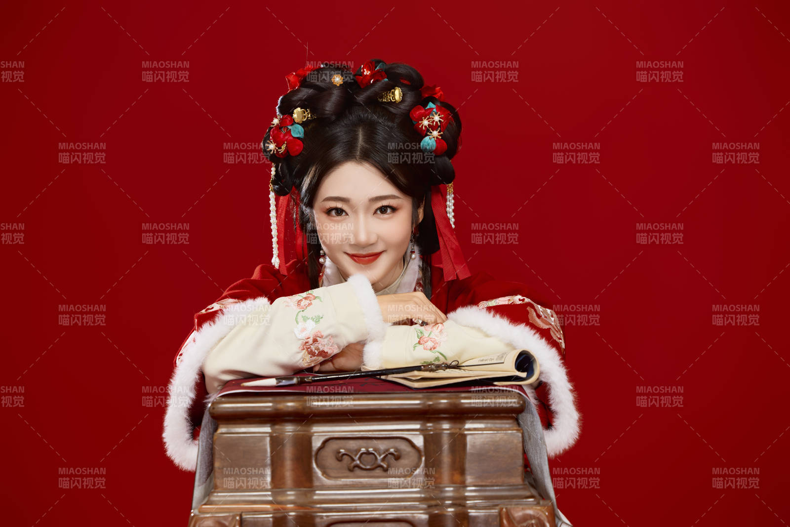 红色背景下身穿喜庆汉服认真学习的中国美女图片