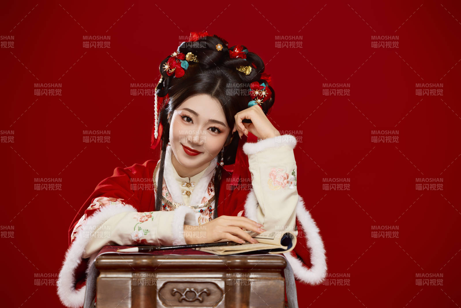 红色背景下身穿喜庆汉服认真学习的中国美女图片