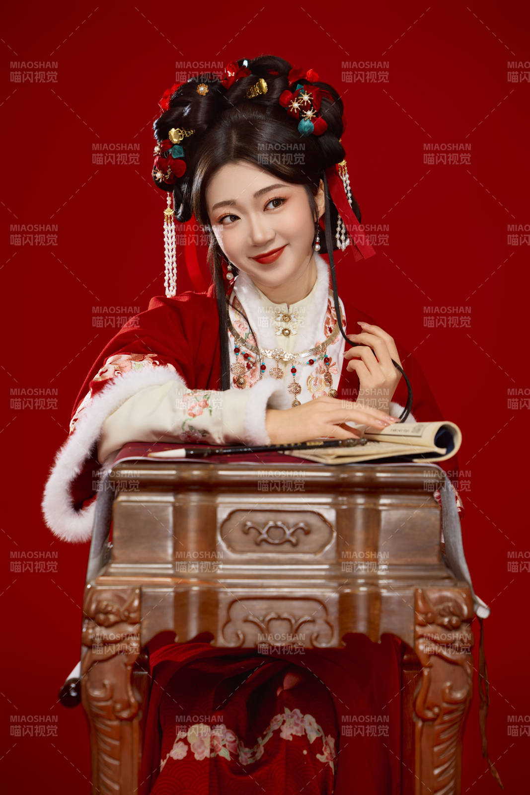红色背景下身穿喜庆汉服认真学习的中国美女图片