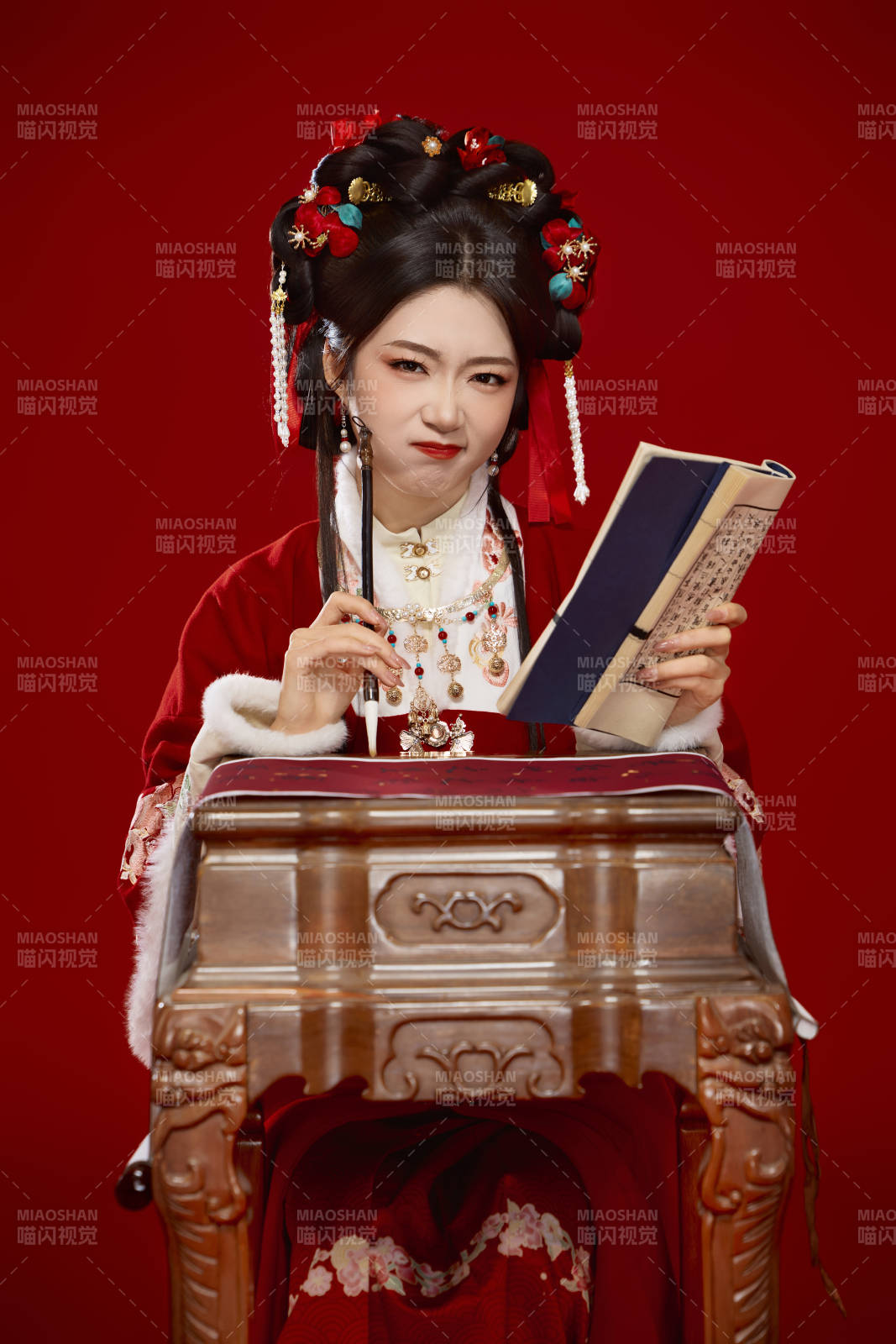 红色背景下身穿喜庆汉服认真学习的中国美女图片