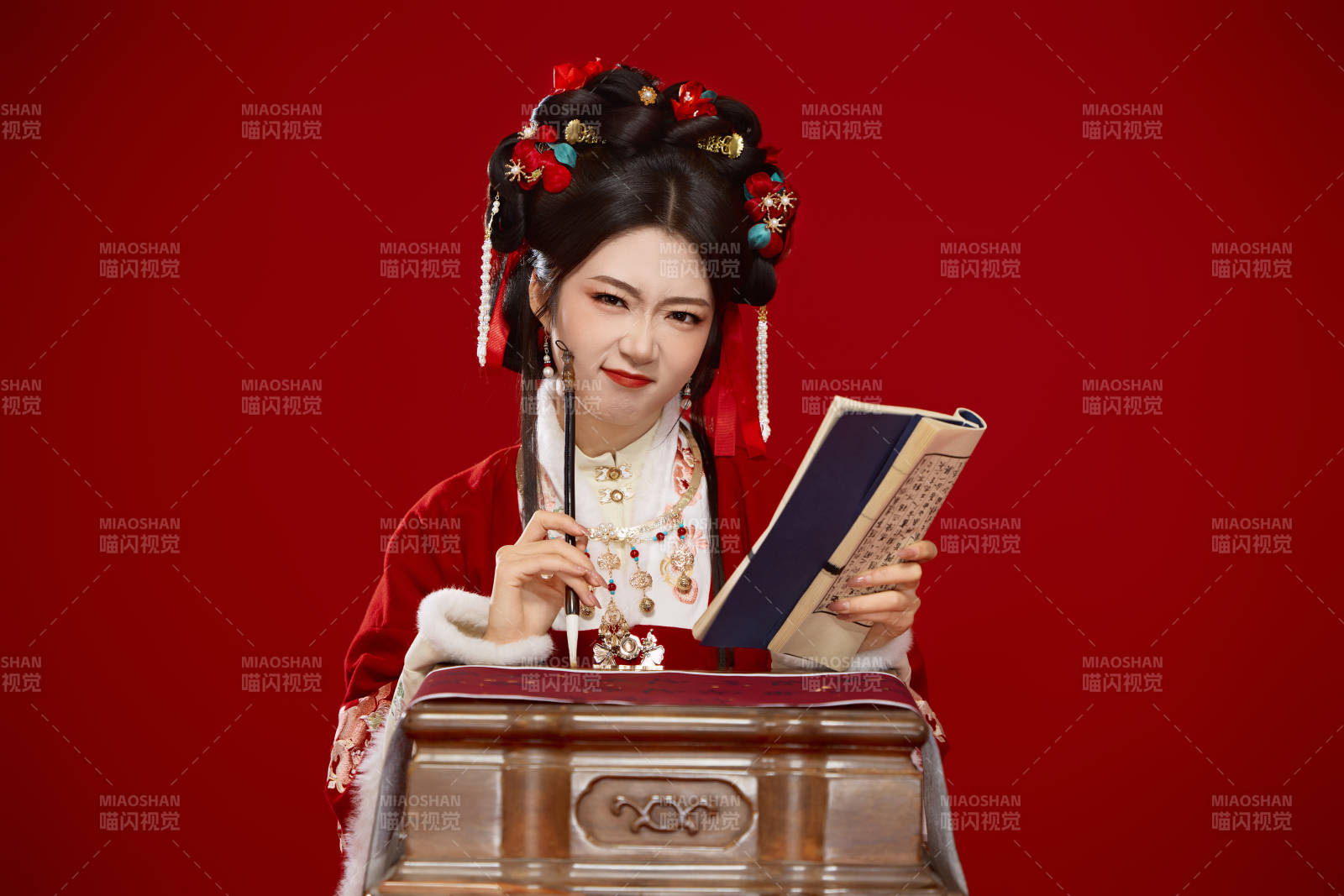 红色背景下身穿喜庆汉服认真学习的中国美女图片