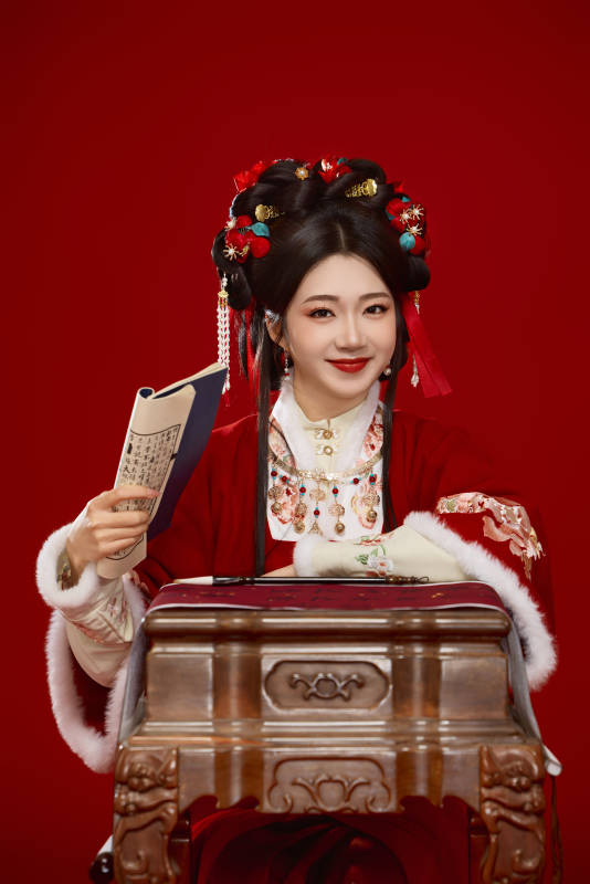 红色背景下身穿喜庆汉服认真学习的中国美女图片
